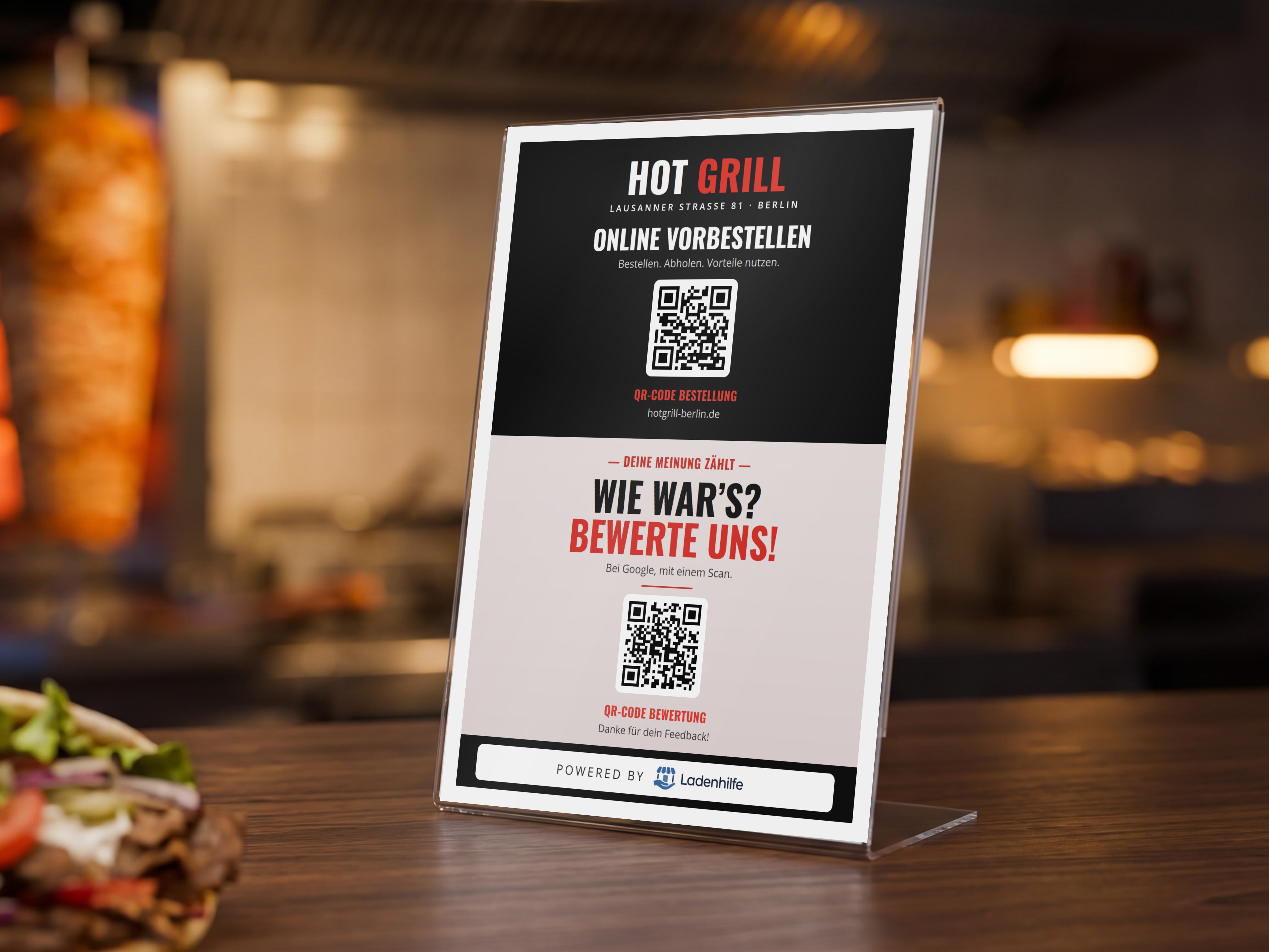 Aufsteller mit QR-Codes zum Bestellen und zum Bewerten auf einer Imbiss-Theke