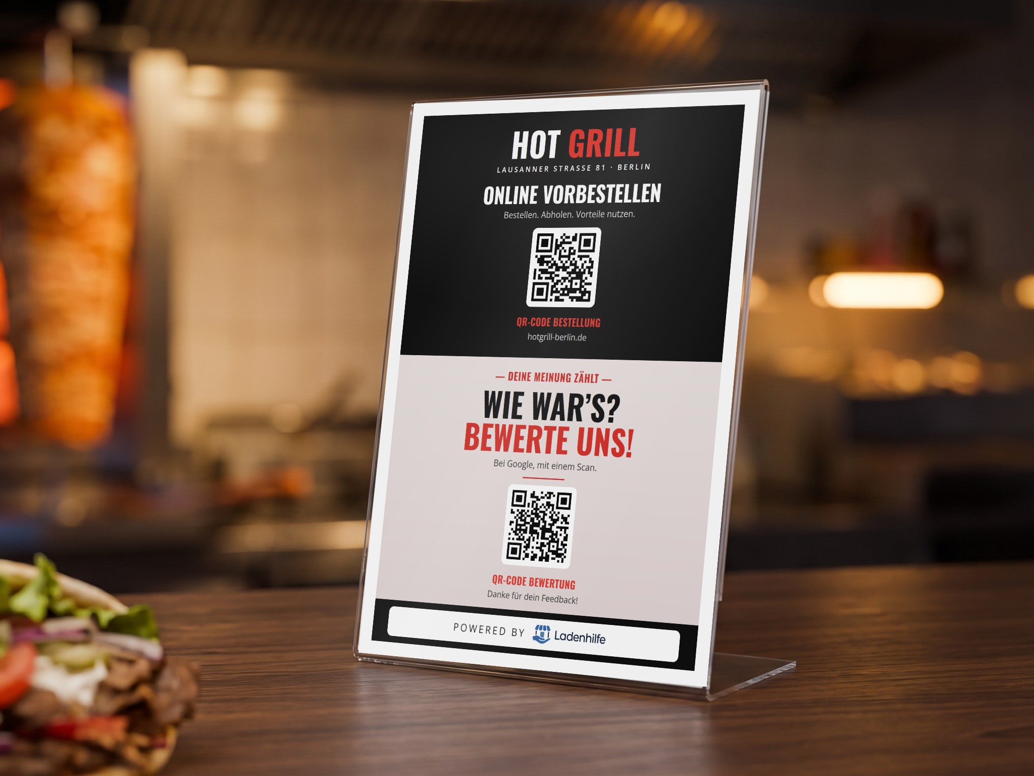 Aufsteller mit QR-Codes zum Bestellen und zum Bewerten auf einer Imbiss-Theke